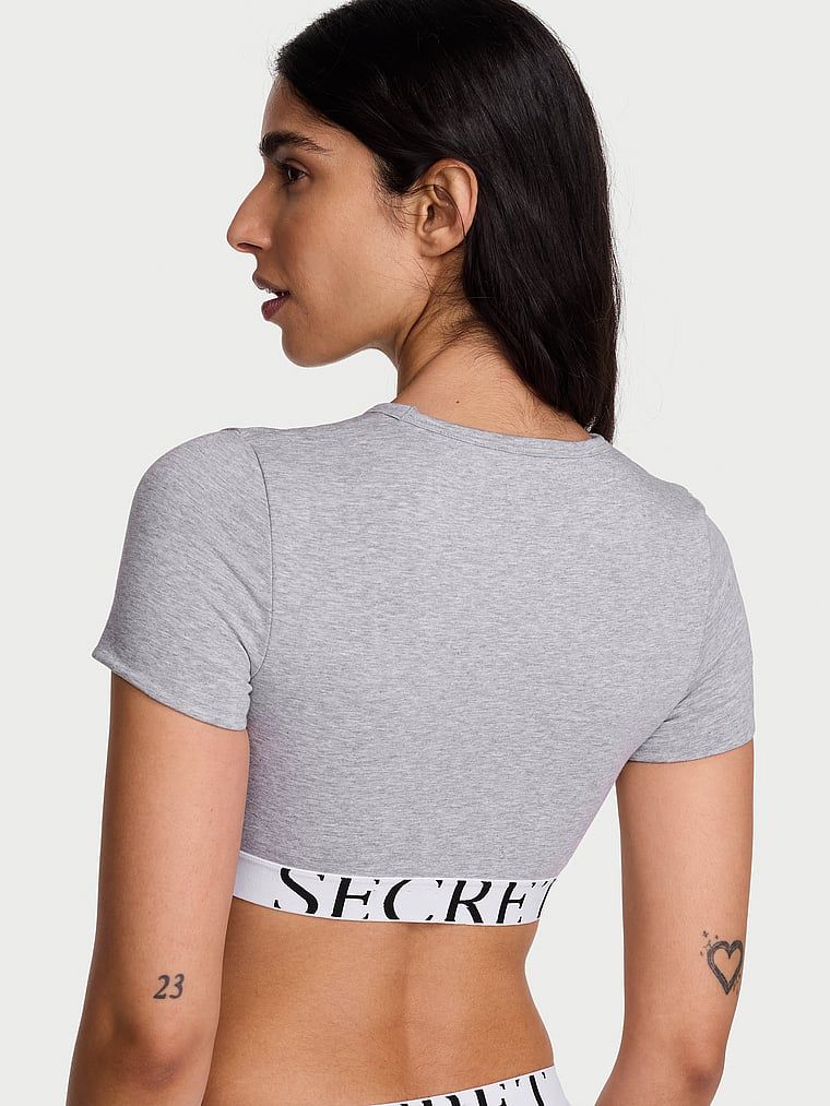 Bavlněný crop top s krátkými rukávy. Produkt je šedé barvy a pochází z kolekce triček.