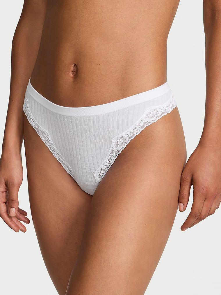 Tanga s krajkou na okrajích z bezešvého žebrování. Produkt je bílý a pochází z kolekce Body by Victoria.