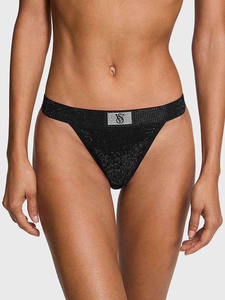 Bavlněná tanga s flitry a lesklým logem Shine. Výrobek je černý a pochází z kolekce Cotton.