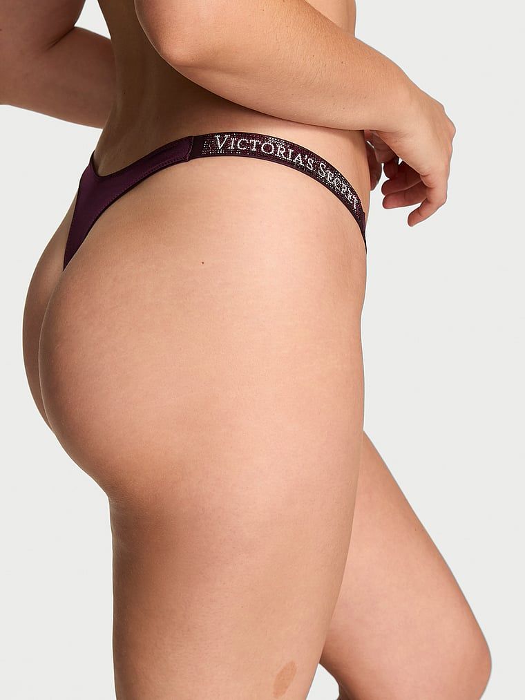 Tanga s lesklými ramínky Shine Strap. Produkt je fialové barvy a pochází z kolekce Very Sexy.