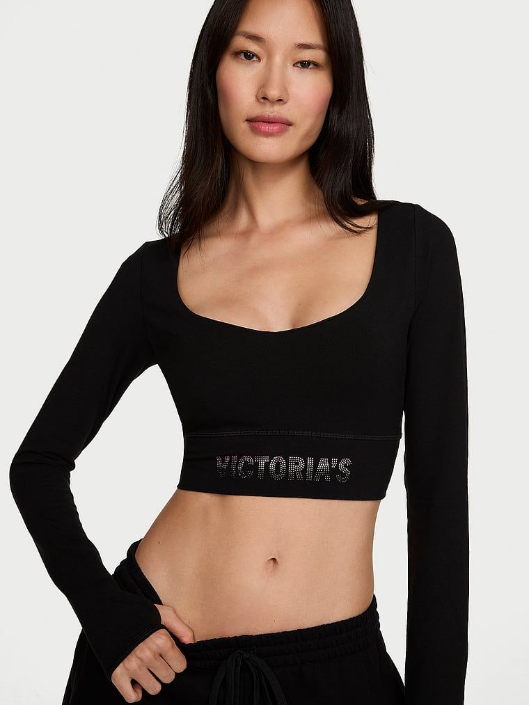 Bavlněný crop top s dlouhým rukávem. Produkt je černý a pochází z kolekce Angel Essentials.