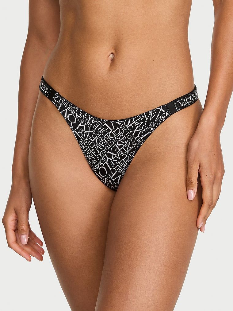 Tanga s lesklými ramínky Shine Strap. Produkt má vzorovanou barvu a pochází z kolekce Very Sexy.