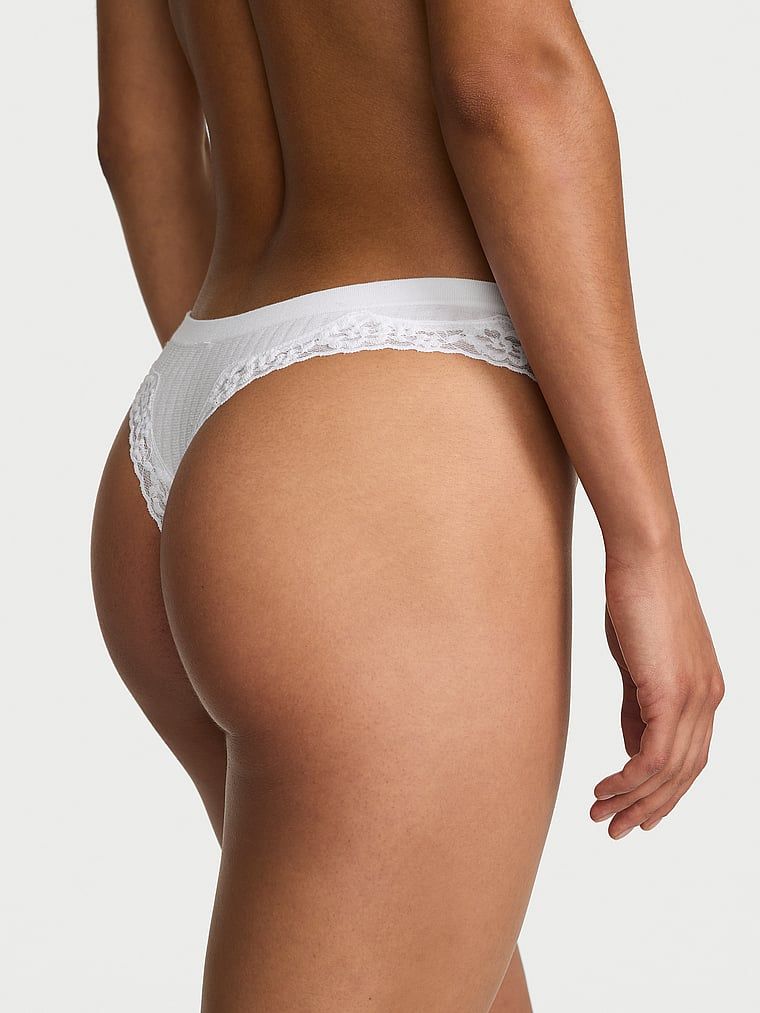 Tanga s krajkou na okrajích z bezešvého žebrování. Produkt je bílý a pochází z kolekce Body by Victoria.