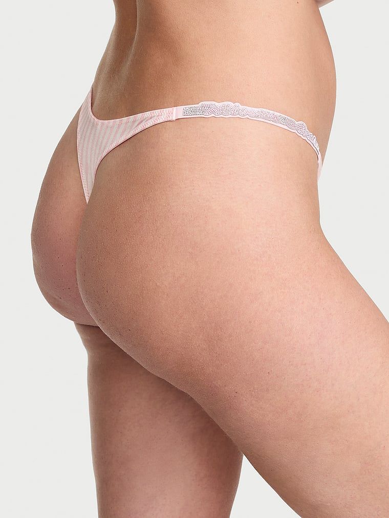 Tanga s lesklými lesklými pásky Script Shine. Produkt má vzorovanou barvu a pochází z kolekce Very Sexy.