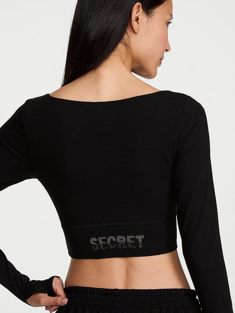 Bavlněný crop top s dlouhým rukávem. Produkt je černý a pochází z kolekce Angel Essentials.