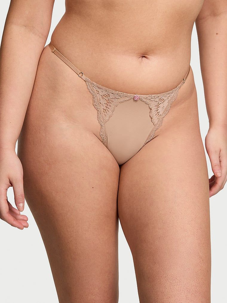 Krajková tanga s nastavitelnými V-String popruhy s lemováním na šněrování. Produkt je béžový a pochází z kolekce Dream Angels.