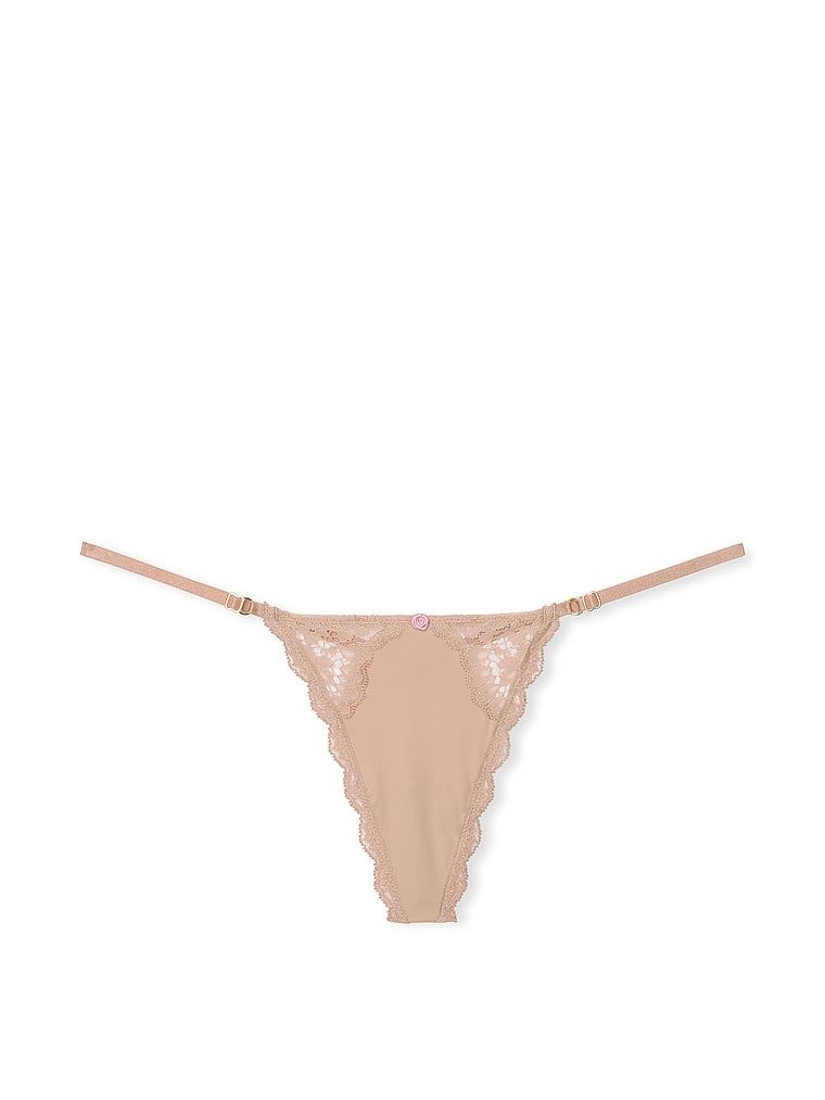 Krajková tanga s nastavitelnými V-String popruhy s lemováním na šněrování. Produkt je béžový a pochází z kolekce Dream Angels.